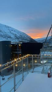 vue d'un bâtiment sous la neige au crépuscule dans l'établissement Cozy apartment on tomasjordnes, à Tomasjorda 3 autres photos