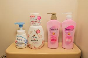 Un grupo de cuatro botellas de detergentes en un estante. en sakura 303, en Tokio