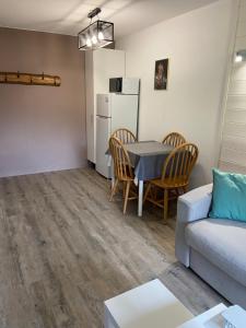 a living room with a table and a couch at Chalets des Evettes- appartement vue montagne in Flumet