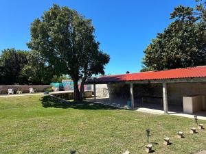 a park with a tree and a building with a red roof at Hotel Don Abel Champotón in Champotón +4 photos