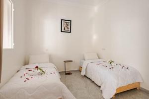 two beds in a room with flowers on them at Retraite Panoramique sur l'Atlas in Ourika