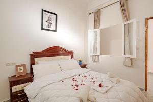 a bedroom with a bed with red rose petals on it at Dar Ourika - Mountain Views in Ourika