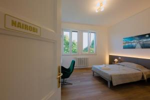 a bedroom with a bed and a chair in it at Camera Nairobi - La Casa di Carta Affittacamere in Udine