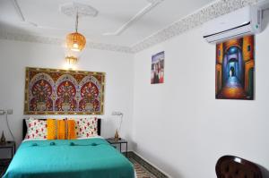 a bedroom with a green bed and colorful pillows at Riad Tafoukt Fes in Fès