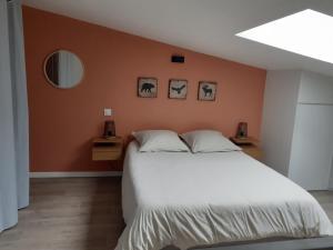 ein Schlafzimmer mit einem großen weißen Bett mit orangefarbenen Wänden in der Unterkunft ELLIE Appartement duplex in Lanester