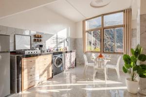 a kitchen with a dishwasher and a table with chairs at Retraite Panoramique sur l'Atlas in Ourika