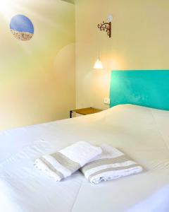 a bedroom with a bed with two towels on it at Suíte no Jardim in Peruíbe