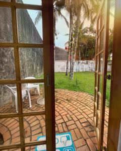 an open door to a patio with a table at Suíte no Jardim à Beira-Mar in Peruíbe