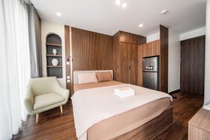 a bedroom with a large bed and a chair at HNT Homestay Đào Tấn - Near Lotte Center in Hanoi