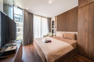 a bedroom with a bed and a desk and a window at HNT Homestay Đào Tấn - Near Lotte Center in Hanoi