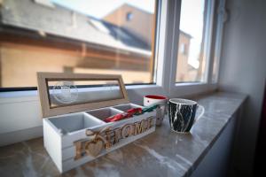 een doos op een toonbank met een foto en een kopje bij Old Town Pearl Apartments in Sarajevo +51 foto's