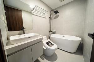a white bathroom with a toilet and a sink at HNT Homestay Đào Tấn - Near Lotte Center in Hanoi