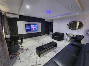 a living room with a couch and a tv at CG Apartments Metro in Ikeja
