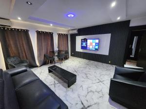 un soggiorno con un divano e una TV di CG Apartments Metro a Ikeja