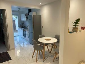 a kitchen with a table and a refrigerator at Pavillion Peuple de l'Herbe in Carrières-sous-Poissy +1 photo
