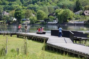 a group of people on a boardwalk near the water at Pavillion Peuple de l'Herbe in Carrières-sous-Poissy