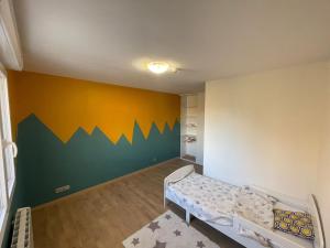 a baby room with a green and yellow wall at Pavillion Peuple de l'Herbe in Carrières-sous-Poissy