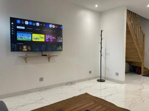 a living room with a flat screen tv on a wall at Pavillion Peuple de l'Herbe in Carrières-sous-Poissy