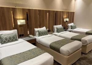 a hotel room with three beds in a room at هندباء Hindibaa in Al ‘Azīzīyah +38 photos