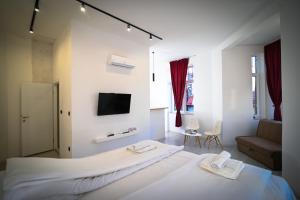 een slaapkamer met een groot wit bed en een tv bij Old Town Pearl Apartments in Sarajevo
