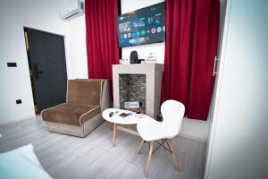 een woonkamer met een stoel en een tafel bij Old Town Pearl Apartments in Sarajevo