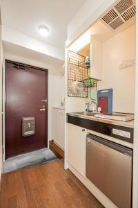 a kitchen with a brown door and a sink at sakura 403 in Tokyo