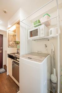 a white kitchen with a sink and a refrigerator at sakura 403 in Tokyo
