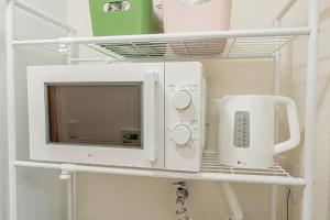 a microwave and a mixer on a shelf in a kitchen at sakura 403 in Tokyo