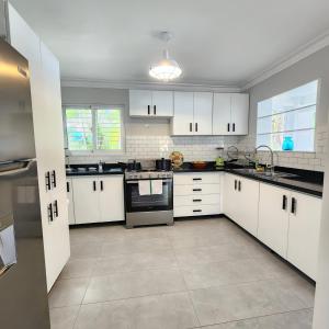 a large kitchen with white cabinets and appliances at Villa Dominique in Villas del Mar