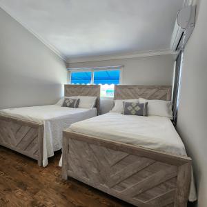 a bedroom with two beds and a window at Villa Dominique in Villas del Mar