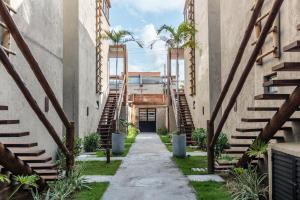 een steegje tussen twee gebouwen met palmbomen bij MHV Milagres - Lanaí 30 Refúgio próximo a Praia a poucos metros da Praia e da Capela dos Milagres in São Miguel dos Milagres