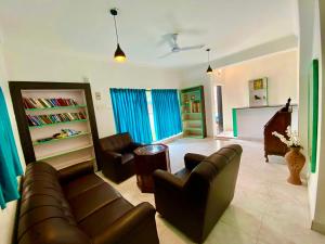 un salon avec un canapé, des chaises et une table dans l'établissement Sana Villa & Resort Goa, à Anjuna