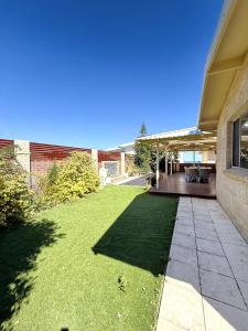a yard of a building with a patio and grass at 24 Sorrento Seabreeze 5br Family Seaside Home in Perth +34 photos