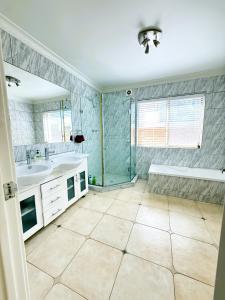 a bathroom with a tub and a sink and a shower at 24 Sorrento Seabreeze 5br Family Seaside Home in Perth