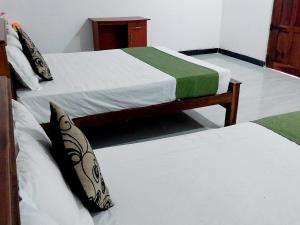 two twin beds in a room with at Green Lake Sigiriya in Sigiriya