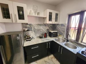 una piccola cucina con lavello e microonde di CG Apartments Metro a Ikeja