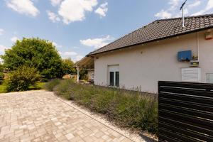 een huis met een zwart hek naast een oprit bij Csillag Vendégház Mórahalom in Mórahalom