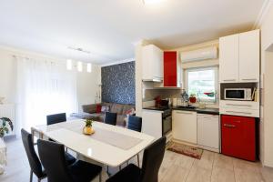 een keuken en woonkamer met een tafel en stoelen bij Csillag Vendégház Mórahalom in Mórahalom