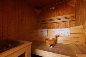een houten sauna met een emmer en handdoeken bij Csillag Vendégház Mórahalom in Mórahalom