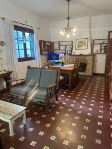 a living room with a table and chairs and a fireplace at Alquilo Casa Miramar in Miramar