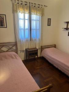a bedroom with two beds and a window at Alquilo Casa Miramar in Miramar