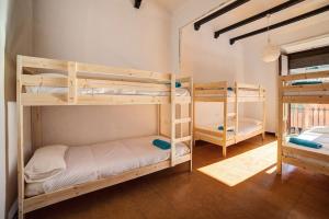 a room with three bunk beds in a room at Pensión Jordi Tossa de Mar in Tossa de Mar