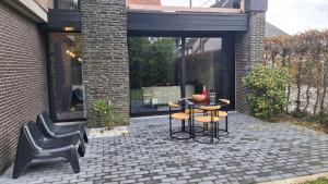 a patio with two chairs and a table and two stools at Vichte groundfloor apartment 