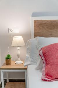 a bed with a table with a lamp and a plant on it at Marea Ferrers 1 in Tarragona
