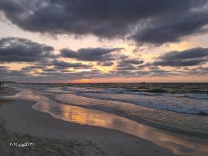 a beach with a cloudy sky and the ocean at شقة بحر إسكندرية Bianchi Breeze in Alexandria