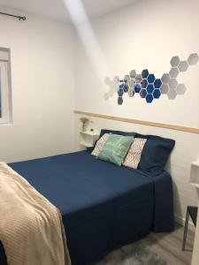 a bedroom with a bed with blue sheets and a wall at Casa da Oliveira 