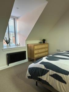 ein Schlafzimmer mit einem Bett, einer Kommode und einem Fenster in der Unterkunft Coorie-In Cottage in Whitehills