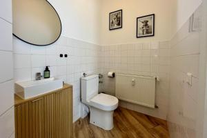 a bathroom with a toilet and a sink and a mirror at Maisonette-Apartment für bis zu 6 Personen - Parkplatz - WLAN - Kingsize in Berlin +12 photos