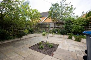 eine Terrasse mit einem Garten, der von einem Zaun und Bäumen umgeben ist in der Unterkunft Brook - Sizewell - Contractor Accommodation in Saxmundham