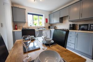 eine Küche mit einem Holztisch mit Weingläsern darauf in der Unterkunft Brook - Sizewell - Contractor Accommodation in Saxmundham